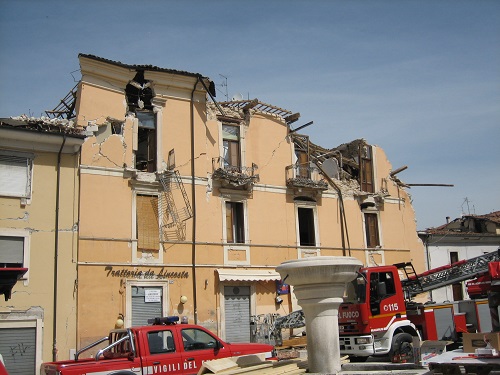 seisme de l'Aquila, secours devant une maison effondrée